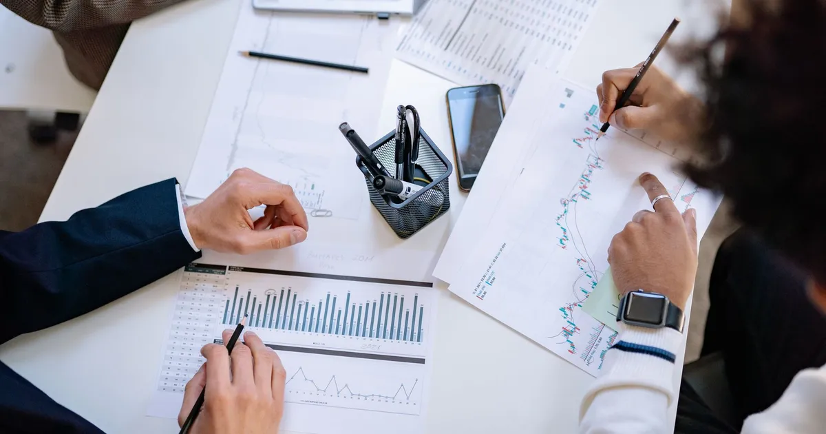 Equipe analisa gráficos de mercado financeiro, indicando compasso de espera na política monetária Selic e Fed.