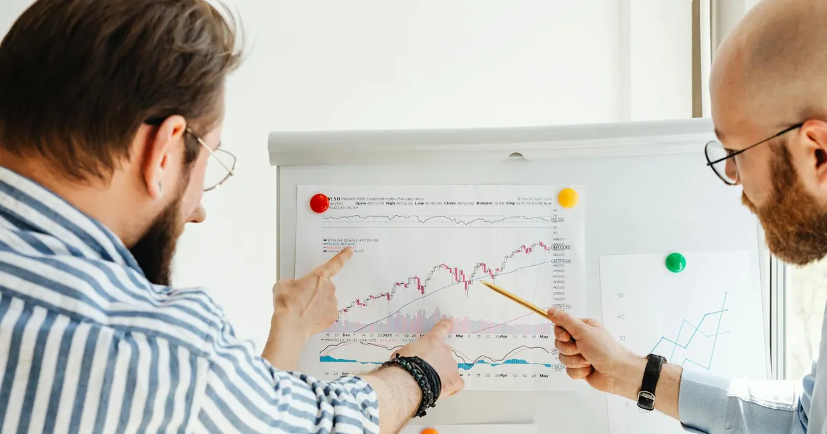 Profissionais analisam gráficos financeiros, refletindo o impacto da Selic e cenário global nos juros.