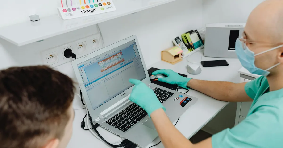 Dentista explica diagnóstico a paciente em clínica. Piso salarial para médicos e dentistas aprovado no Senado.