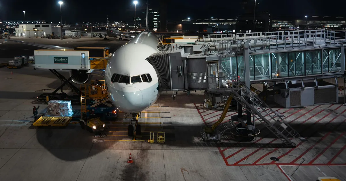 Avião em aeroporto à noite, simbolizando transporte de cargas e passageiros na economia de serviços e turismo.
