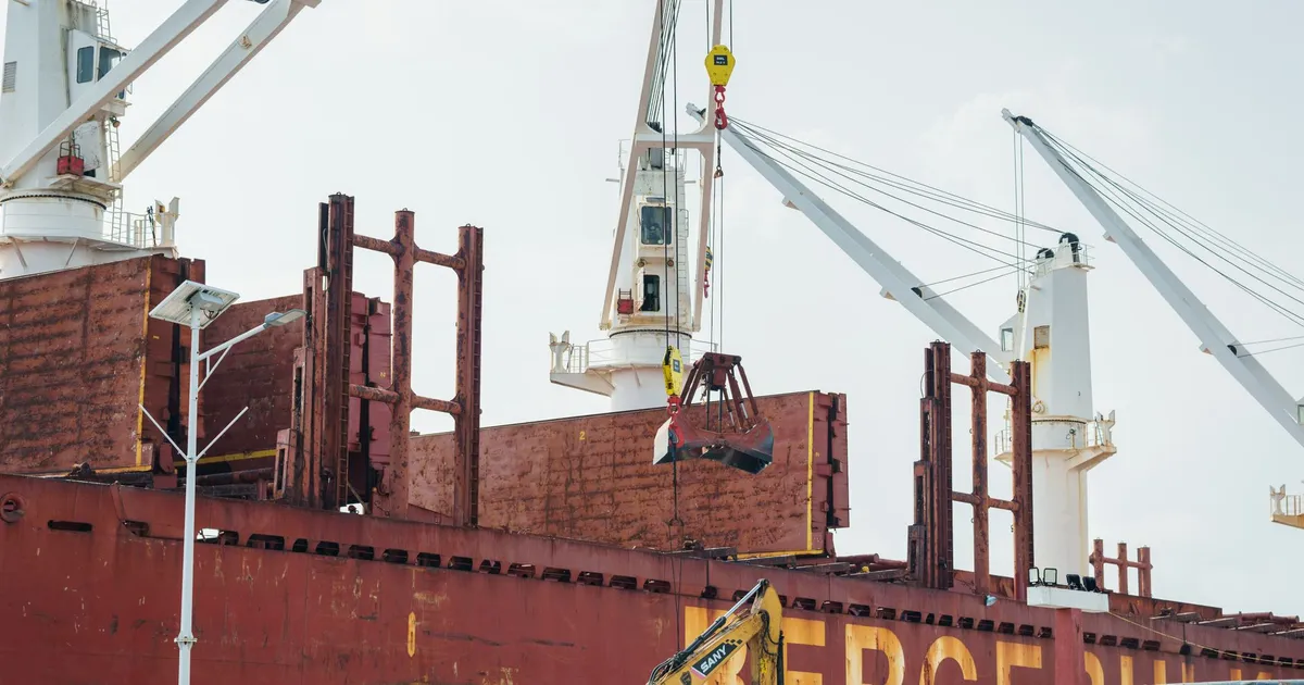 Navio cargueiro com contêineres em porto: símbolo do recorde de superávit comercial e exportações brasileiras.