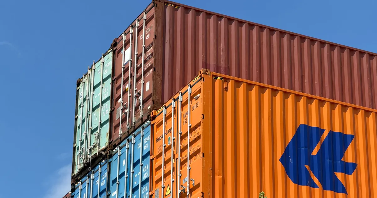 Contêineres de exportação Brasil em área de armazenamento nos EUA, impactados por tarifas comerciais de Trump.