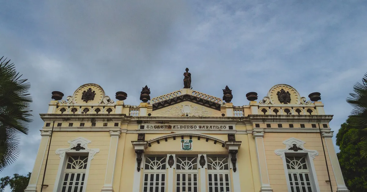 Flávio Bolsonaro culpado em pesquisa sobre Tarifaço, com fachada do Teatro Alberto Maranhão.
