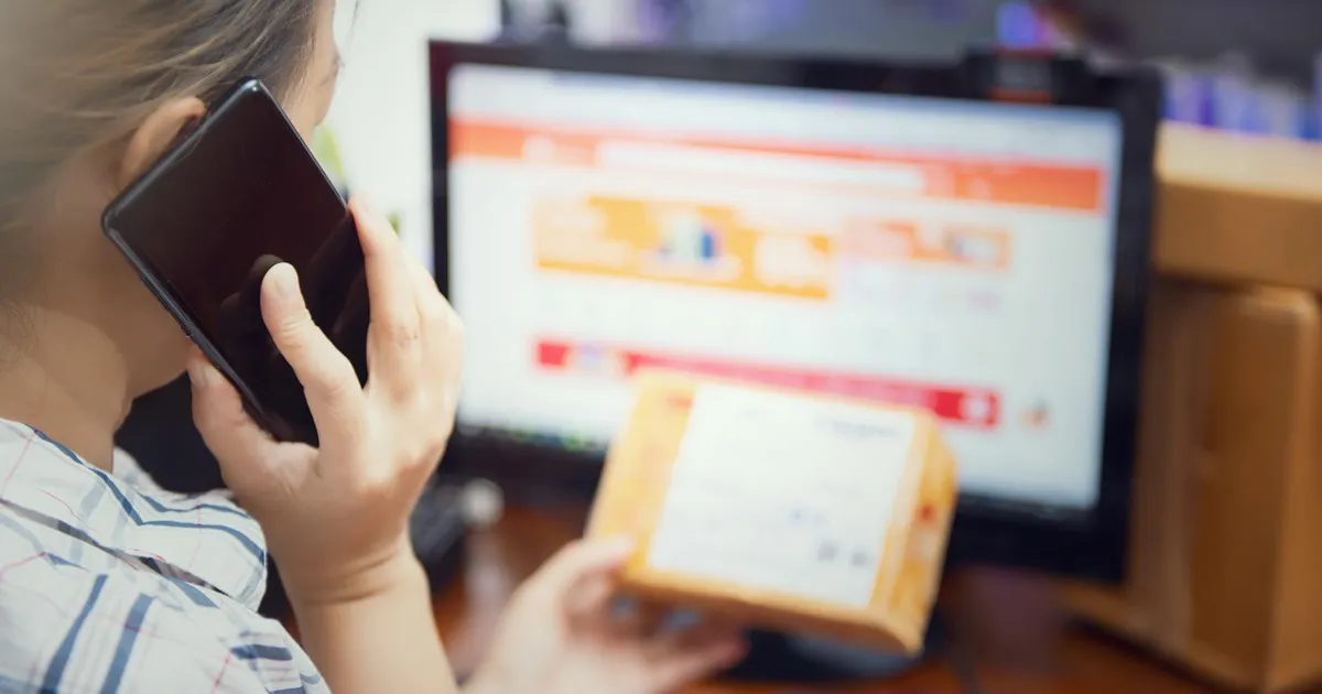 Compra online e imposto: Mulher confere pacote em casa. Impacto da taxa de importação no e-commerce. Lula e economia.