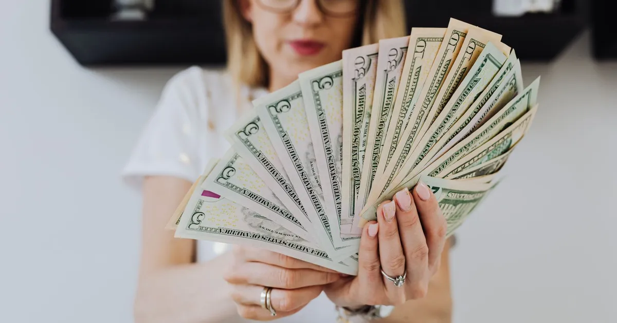 Trabalhador conta com lucro FGTS liberado, mulher com dinheiro em mãos para economia brasileira.