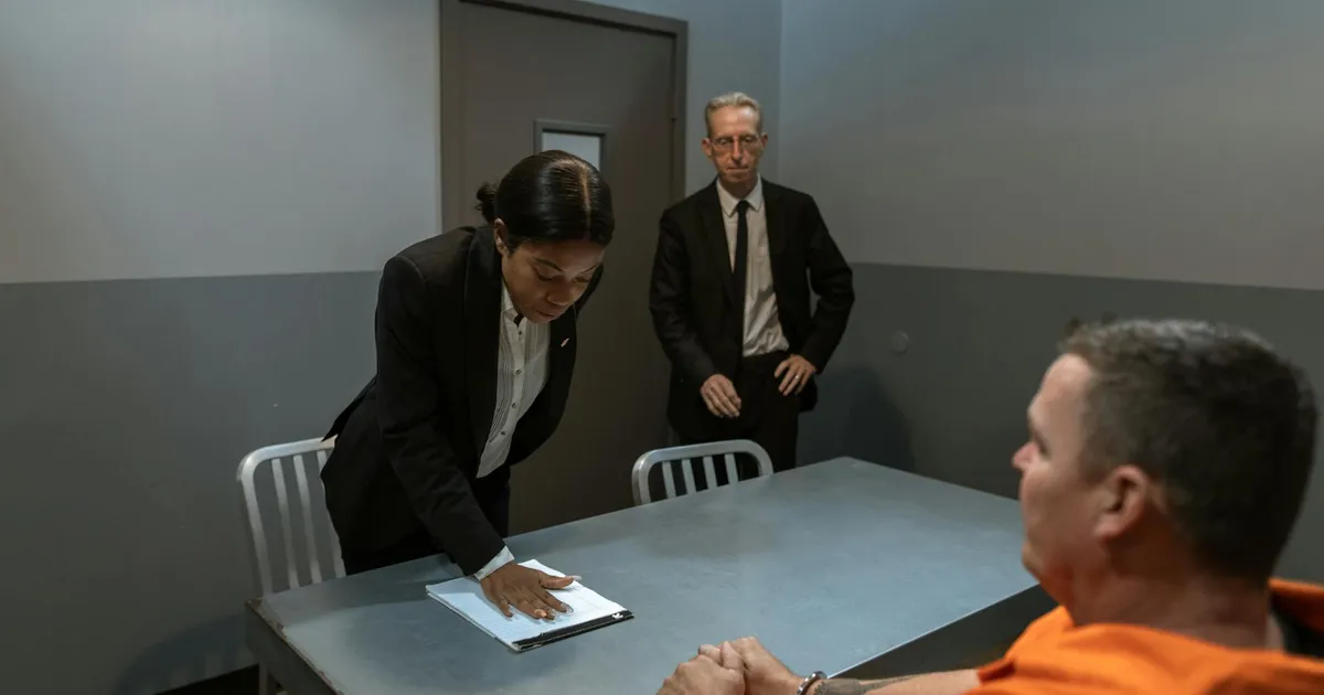 Prisão final: Homem algemado interrogado, representando a justiça do STF na trama golpista.